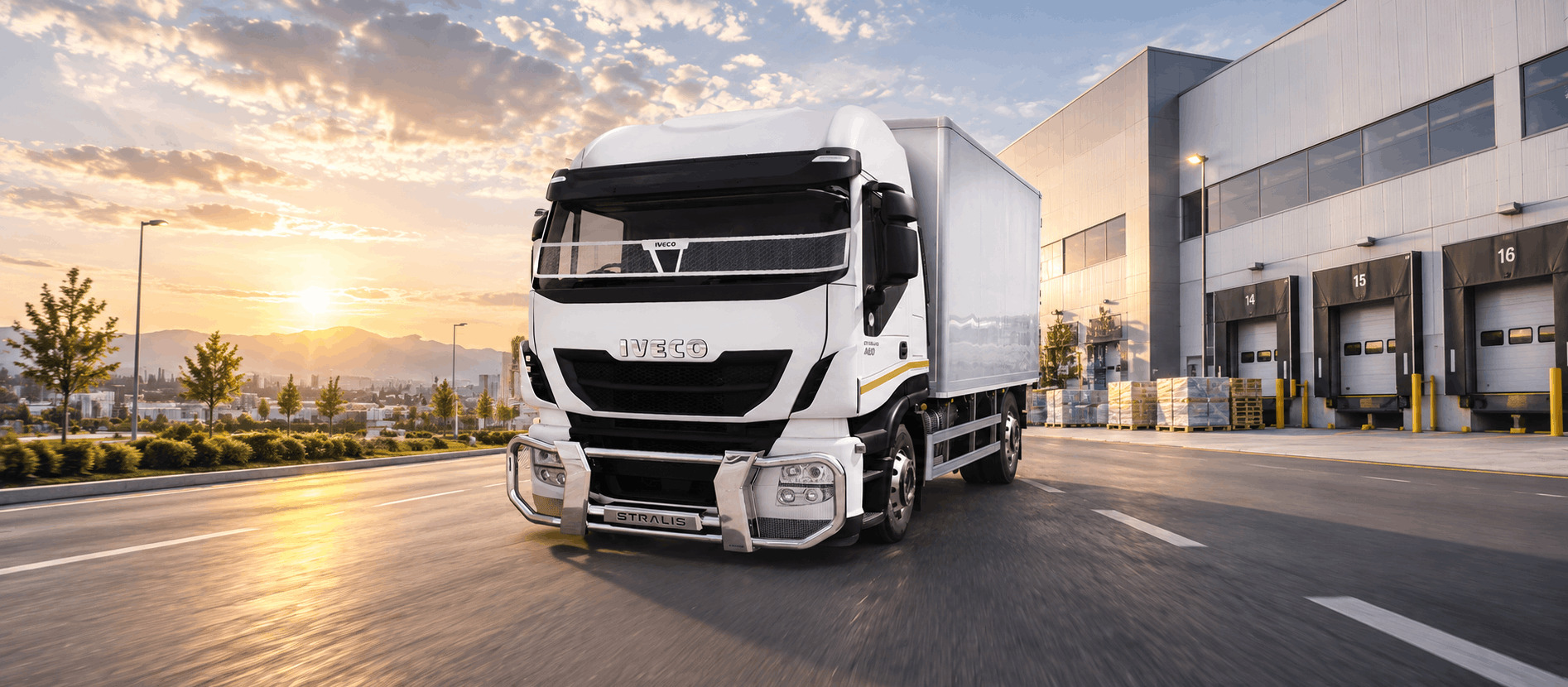 White Iveco Stralis 480/500 truck with MAXE truck bar and screenguard driving past a modern distribution centre at sunset
